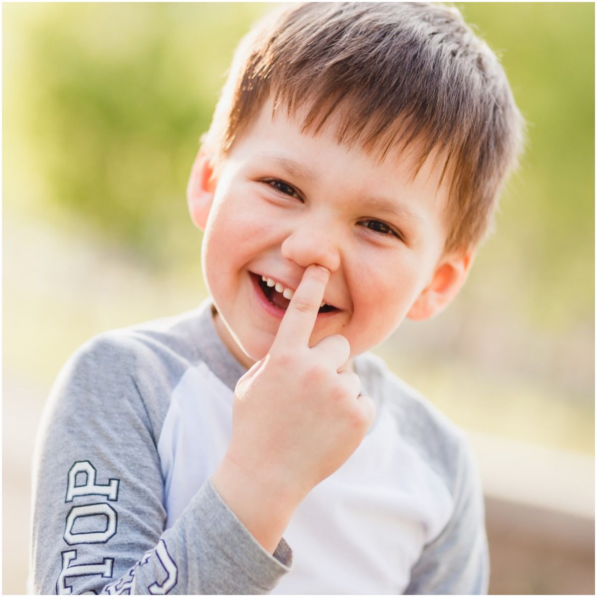 child picks his finger in the nose